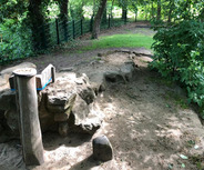 Ein schmaler, ungeteilter Pfad aus Erde und Sand führt über unregelmäßige Steine. 
