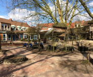 Ein Spielplatz mit verschiedenen Spielgeräten, darunter eine Rutsche und ein Klettergerüst.