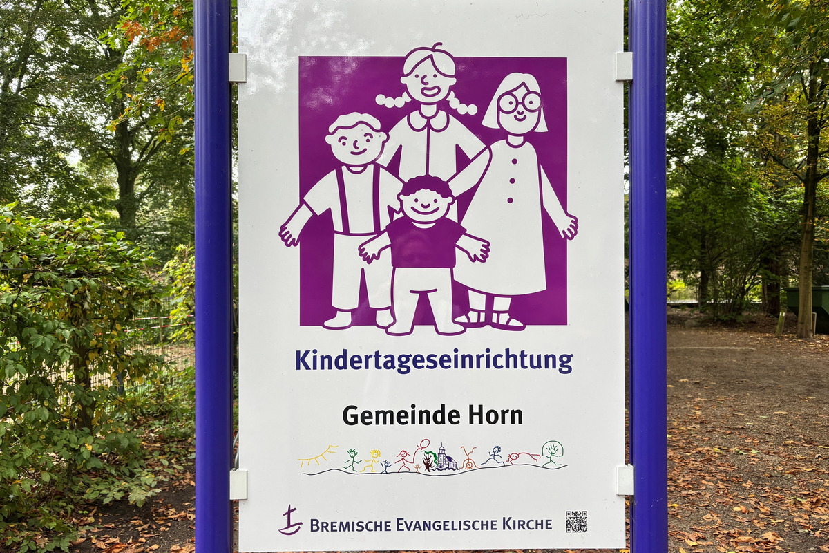 Ein Schild einer Kindertageseinrichtung zeigt eine bunte Illustration von einer Familie mit zwei Erwachsenen und drei Kindern. Darunter steht der Text "Kindertageseinrichtung Gemeinde Horn" und das Logo der Bremischen Evangelischen Kirche. 