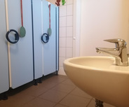 Ein Waschbecken mit einem glänzenden Wasserhahn steht im Vordergrund.