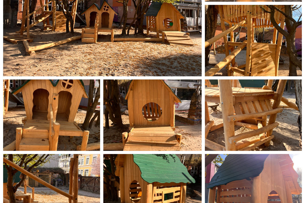 Das Bild zeigt einen Spielplatz mit Holzspielgeräten, darunter mehrere kleine Spielhäuser, Rutschen und Kletterelemente. 