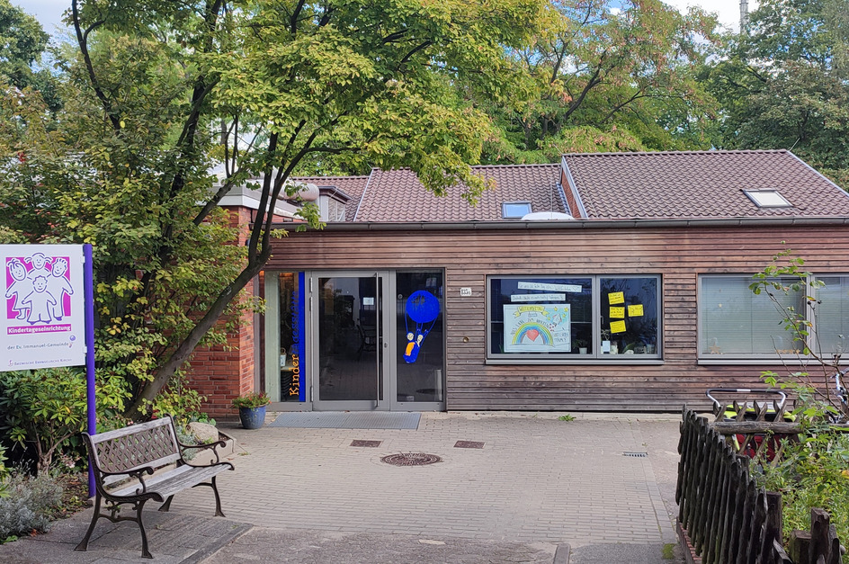 Ein modernes Holzgebäude mit großen Fenstern, das eine Kindertagesstätte beherbergt.