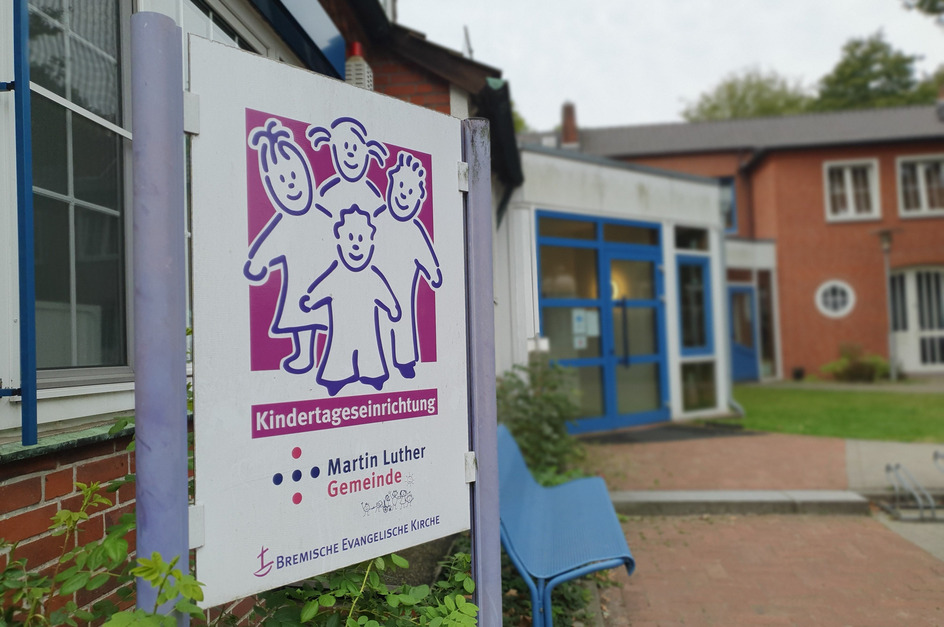 Ein Schild vor einem Gebäude zeigt die Aufschrift „Kindertageseinrichtung Martin Luther Gemeinde“. 