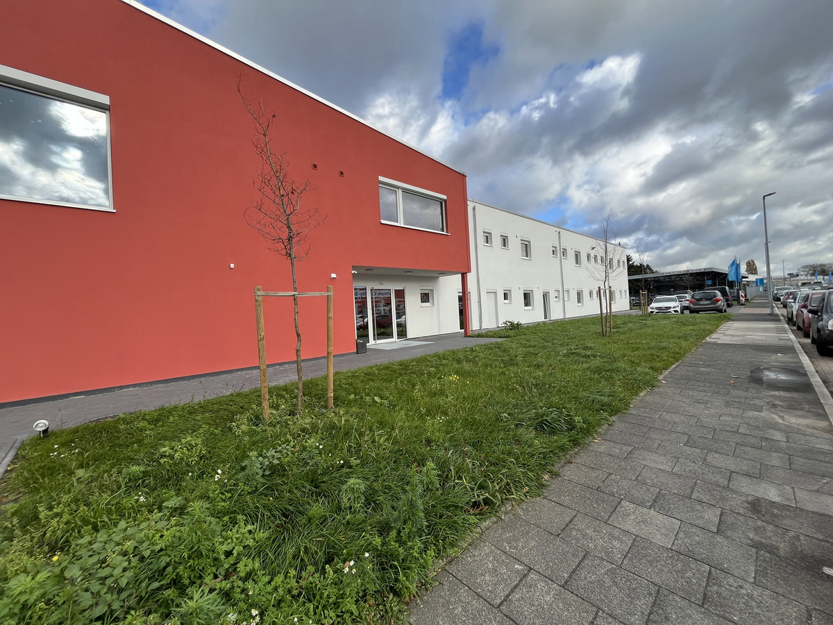 Das Bild zeigt ein modernes Gebäude mit roter und weißer Fassade. 