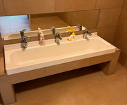 Ein modernes Badezimmer mit einem schlichten, langen Waschbecken für Kinder