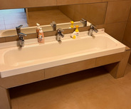 Ein modernes Badezimmer mit einem schlichten, langen Waschbecken für Kinder