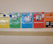 Ein Wochentafel mit farbigen Abschnitten für Montag (gelb), Dienstag (grün), Mittwoch (blau), Donnerstag (rot) und Freitag (orange). Jeder Abschnitt enthält Symbole bzw. Bilder, die Aktivitäten oder Themen der jeweiligen Tage darstellen, um einen klaren Überblick über die Woche zu geben.