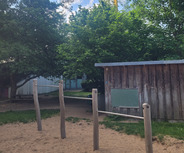Ein Spielplatz mit Holzgestellen im Sand. 