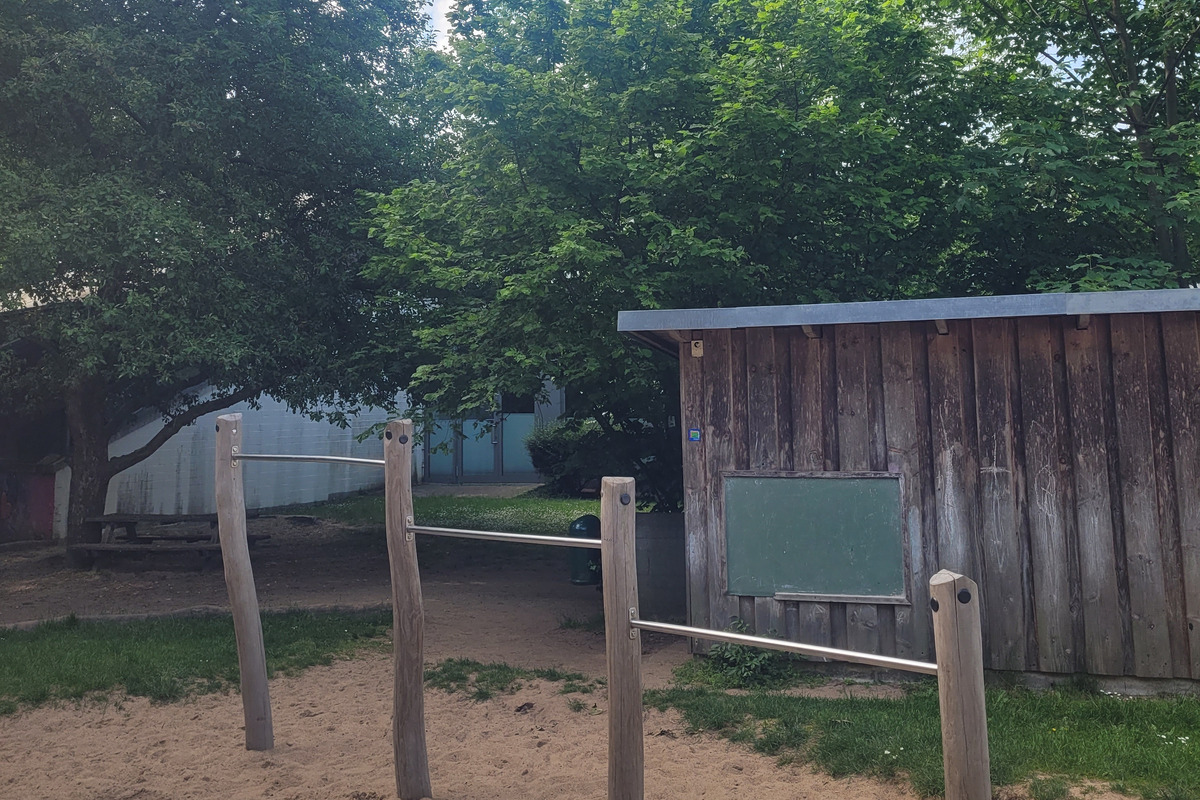 Ein Spielplatz mit Holzgestellen im Sand. 