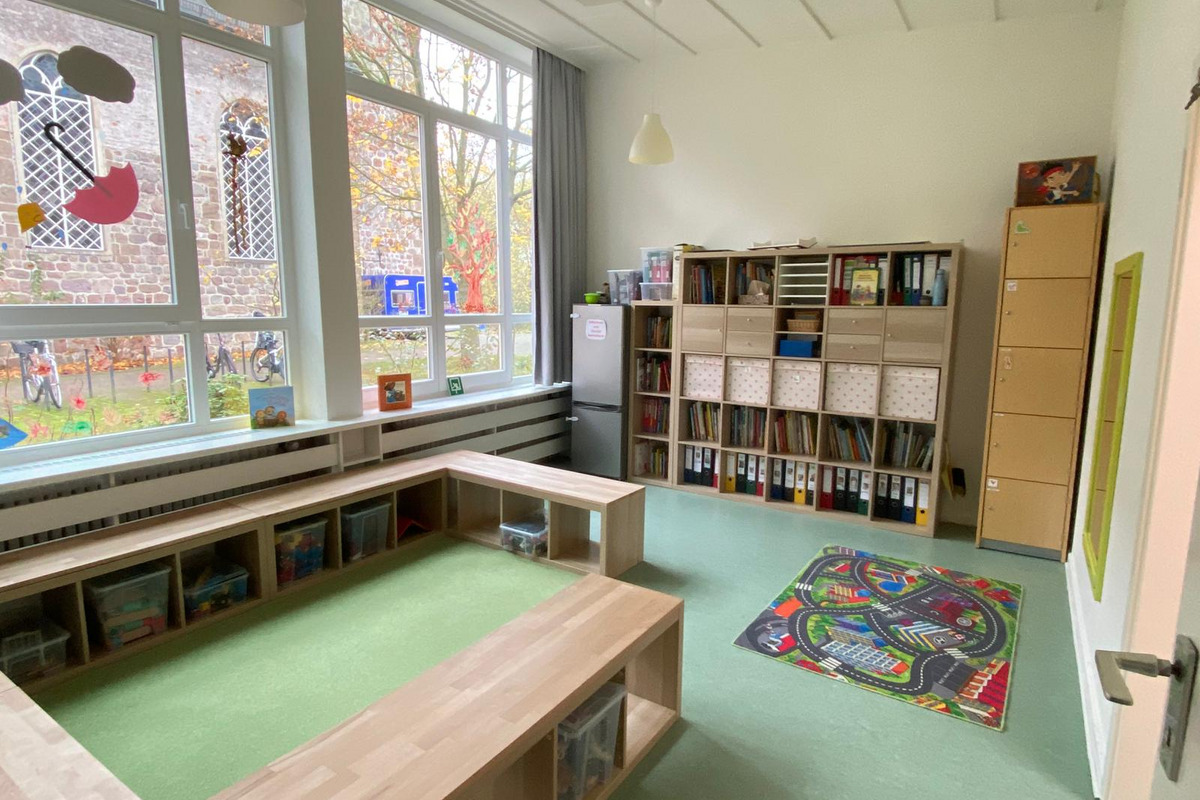 Ein heller Raum mit großen Fenstern, der als Lern- oder Spielbereich dient. 