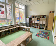 Ein heller Raum mit großen Fenstern, der als Lern- oder Spielbereich dient. 